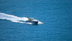 Lancha motora blanca navegando a velocidad sobre aguas azules del mediterráneo dejando estela de espuma