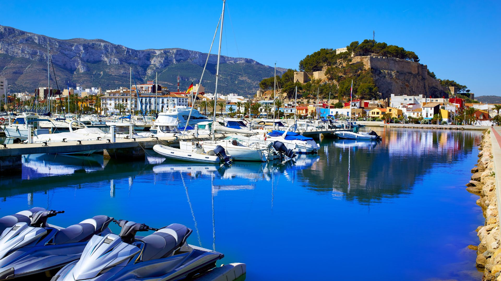 Vista del castillo y el puerto de Denia con el Montgó de fondo