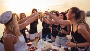 Grupo de amigas celebrando despedida de soltera en barco cerca de Tabarca al atardecer con brindis