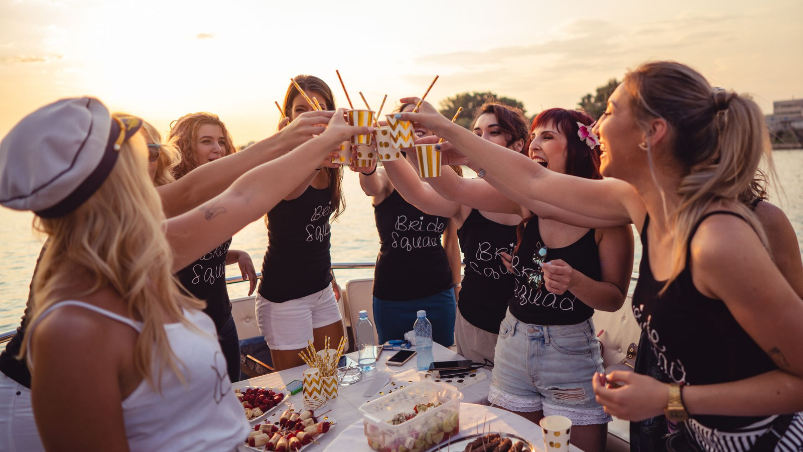 Grupo de amigas celebrando despedida de soltera en barco cerca de Tabarca al atardecer con brindis