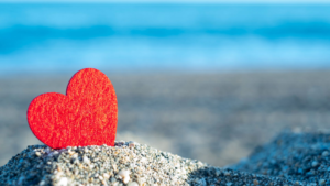 Corazón rojo en la arena de la playa de Tabarca con el mar Mediterráneo azul al fondo, San Valentín