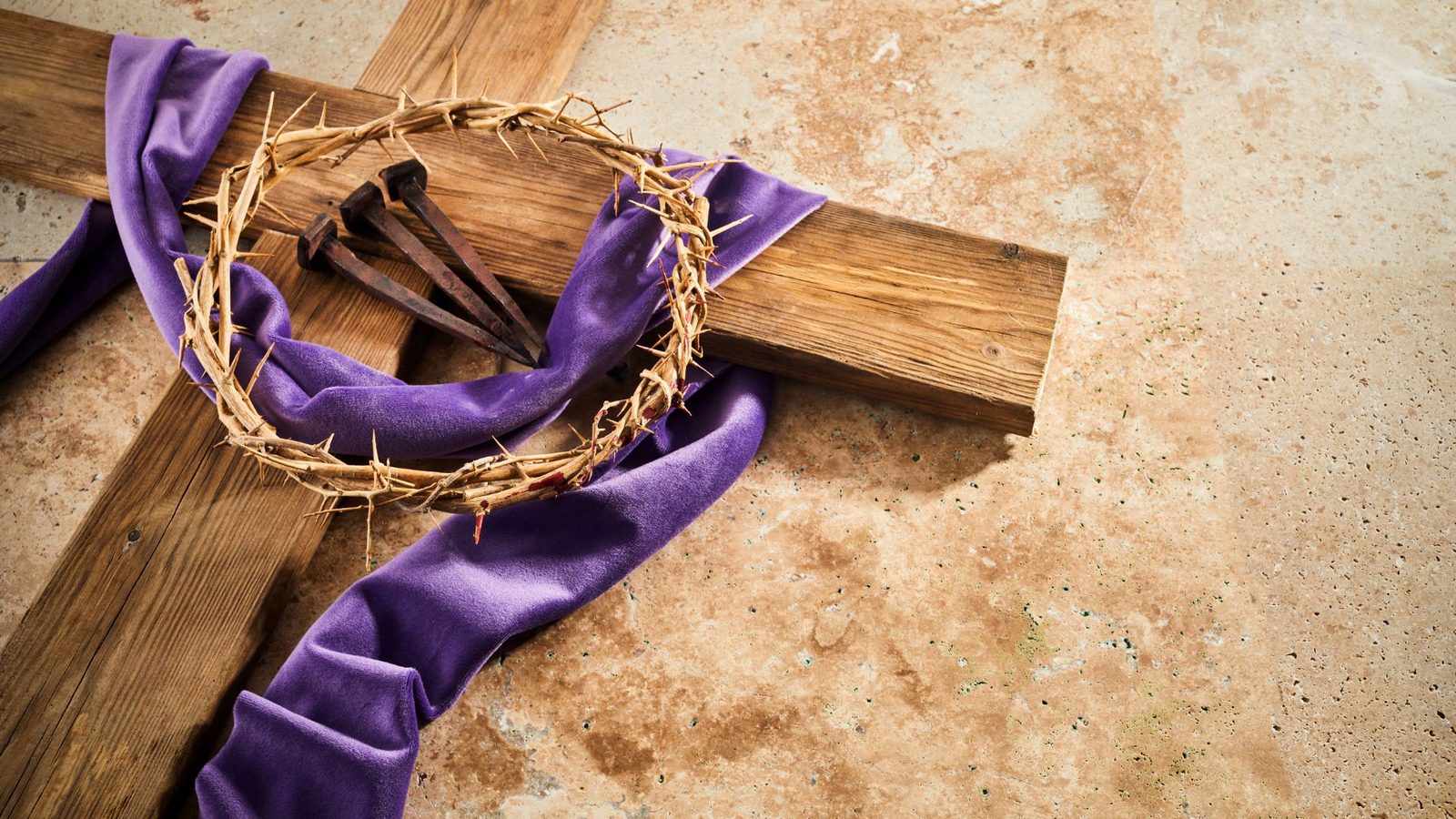 Cruz de madera con corona de espinas, clavos oxidados y manto púrpura, símbolos de la Semana Santa en Tabarca